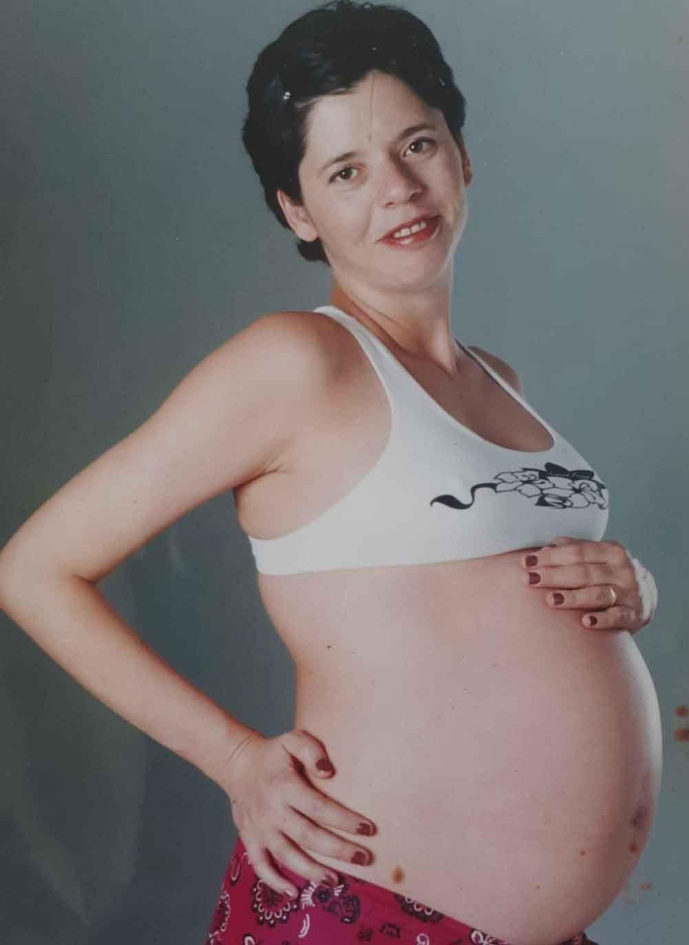 Claudia Visoni posando sorridente e com as mãos na barriga durante a gravidez dos gêmeos. O registro captura um momento de muita expectativa e afeto, que antecedeu a chegada dos filhos em 2001 e marcou o início de uma grande transformação em sua vida pessoal e profissional.